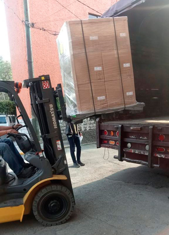 Montacargas metiendo mercancía en caja de camión.