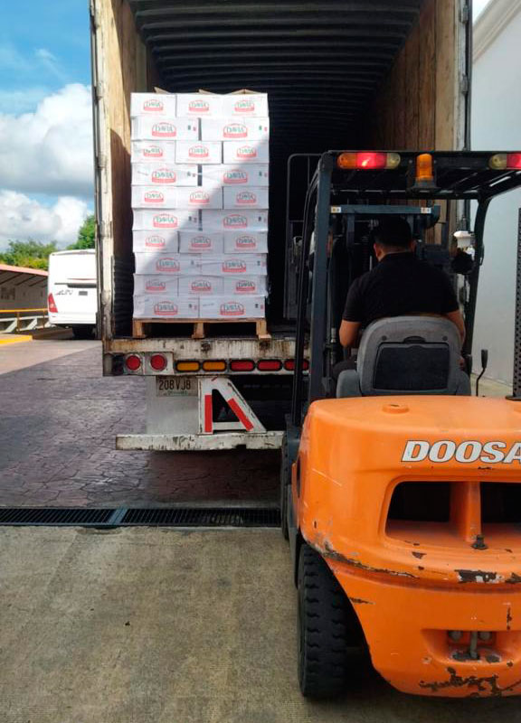 Montacargas metiendo mercancía en caja de camión.