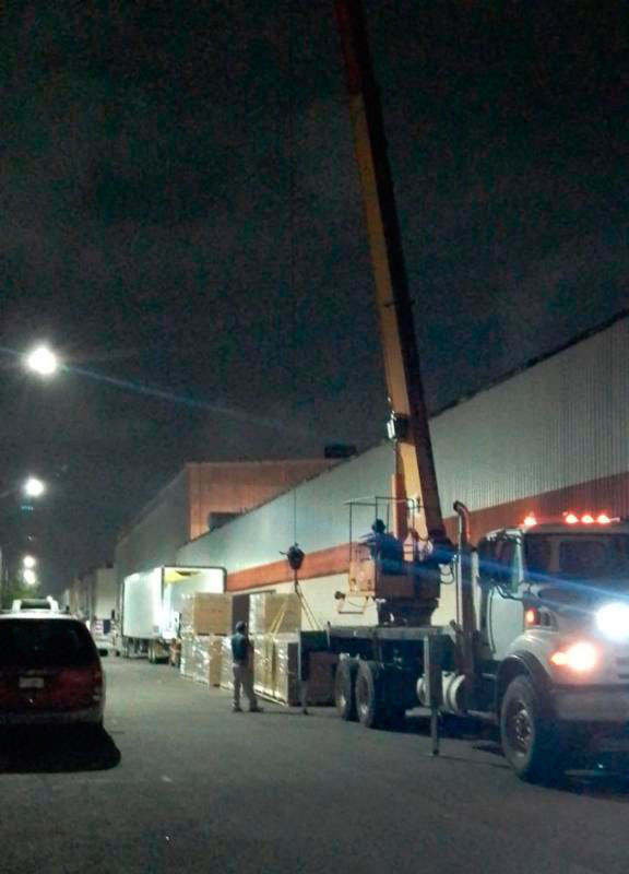 Trabajador verificando mercancía en patín hidráulico.